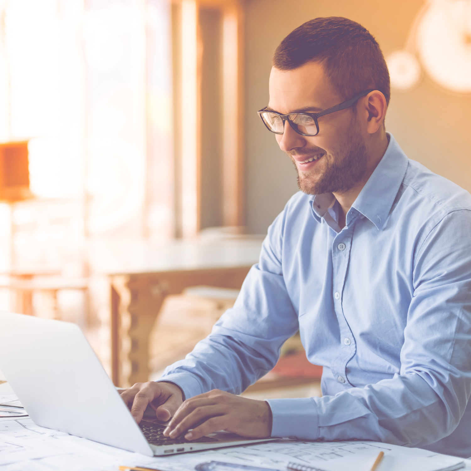 Homme souriant naviguant sur son ordinateur portable